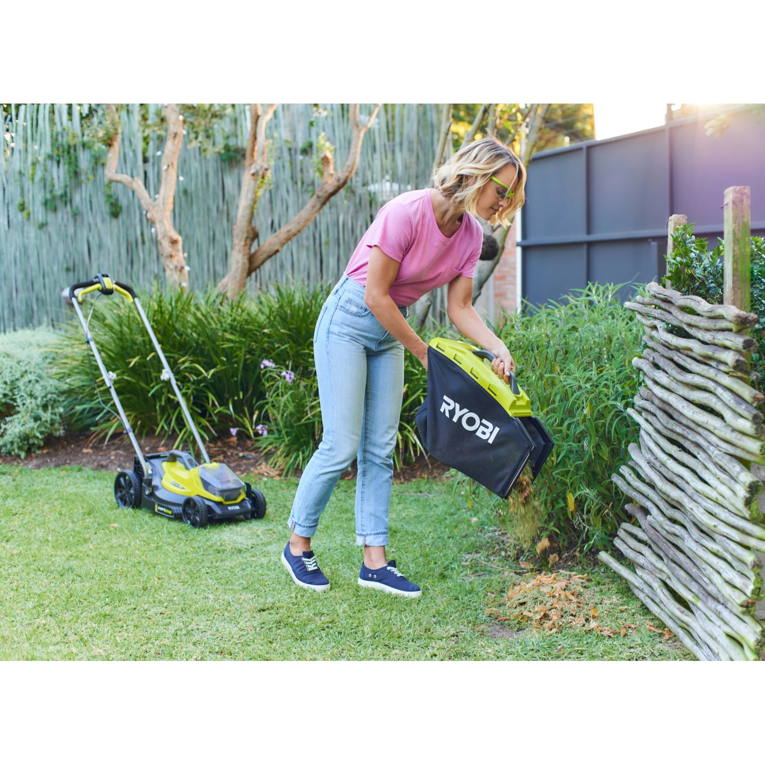 Ryobi Akku-Rasenmäher RLM18X33B40 mit Fangsack im Einsatz im Garten.