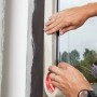 Anwendung von beigem Kip Malerkreppband Masking-Tec (3er-Pack) auf einer Fensterleiste.
