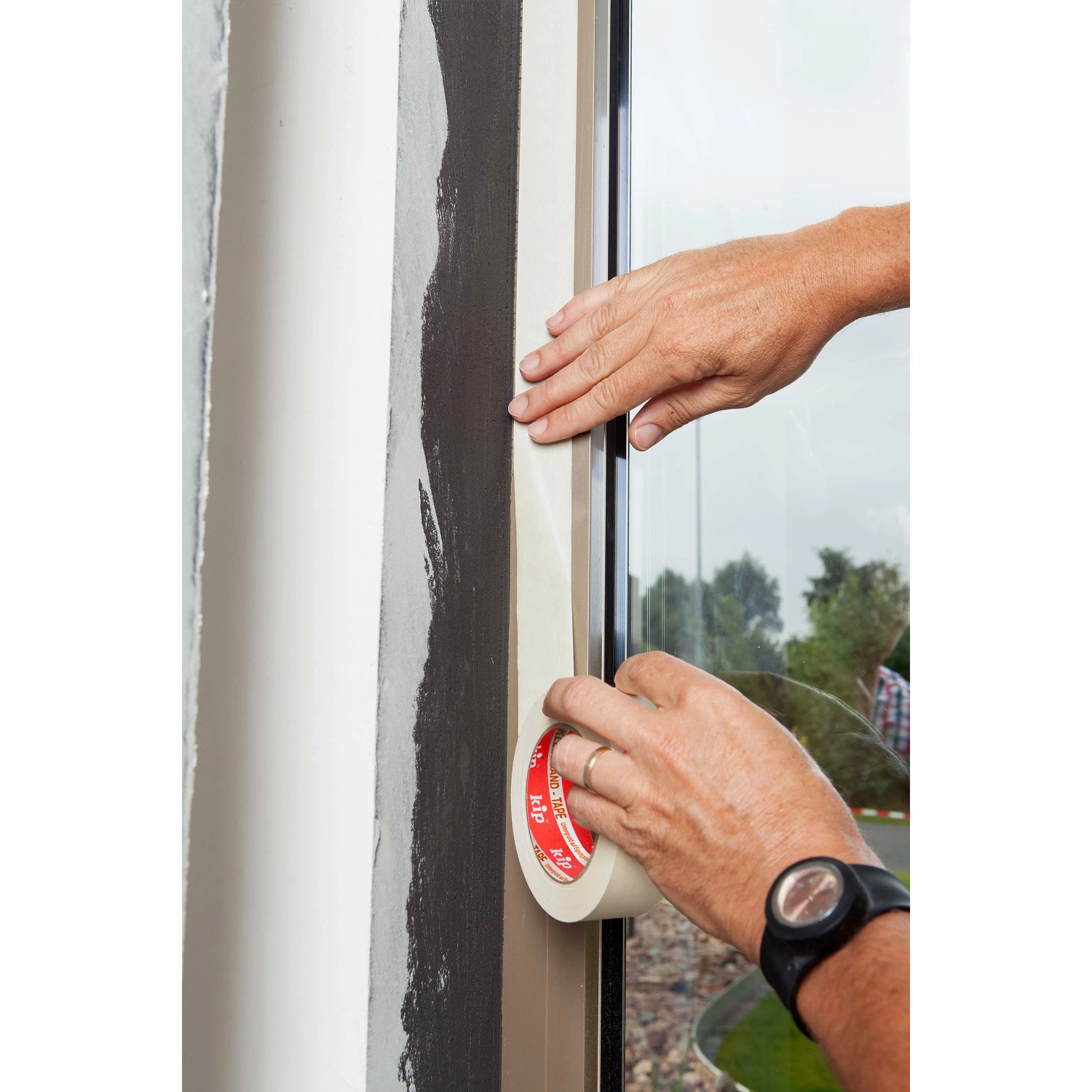 Anwendung von beigem Kip Malerkreppband Masking-Tec (3er-Pack) auf einer Fensterleiste.