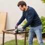 Mann schleift Metall mit dem Bosch UniversalGrind 850-125 Winkelschleifer im Freien.