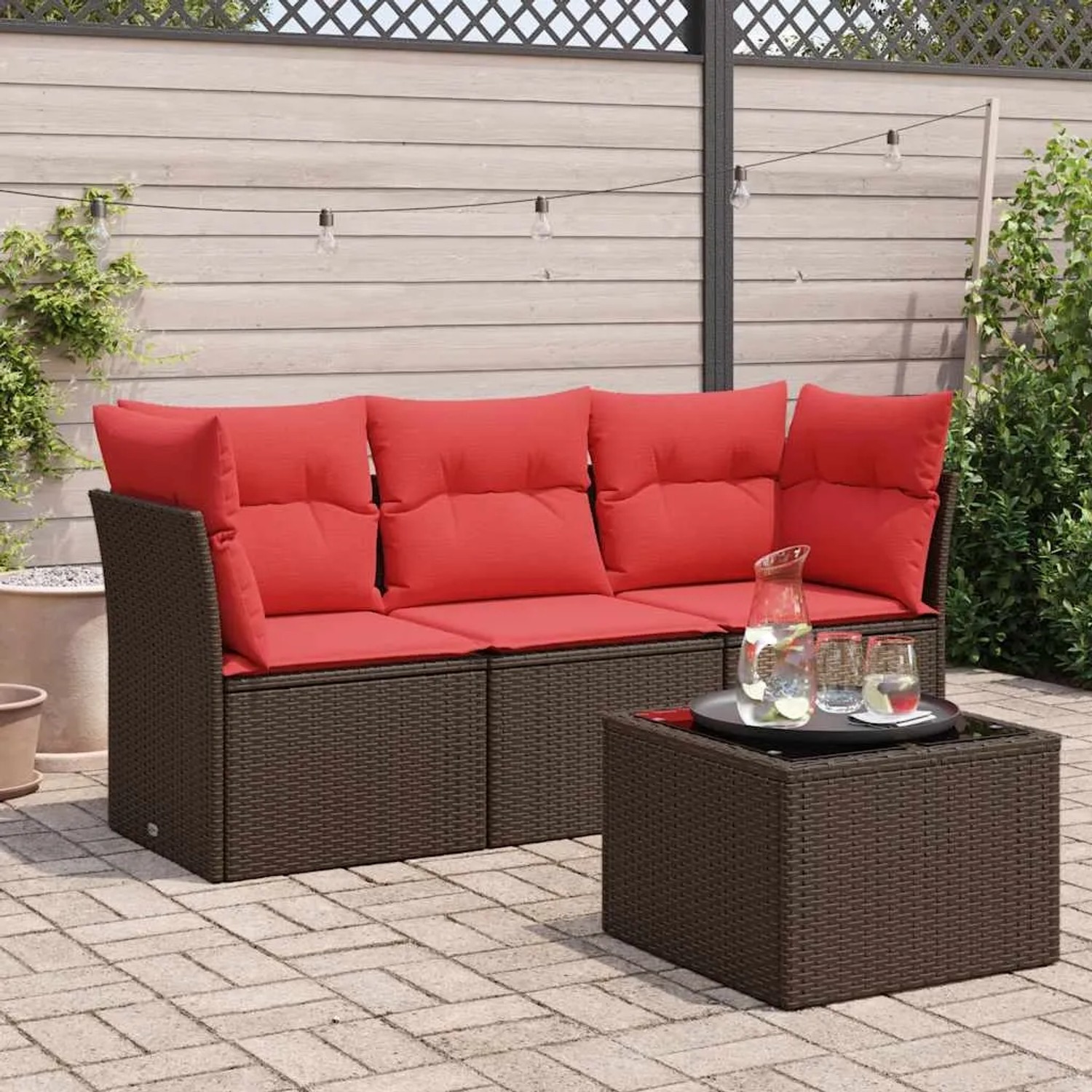 Braune 4-tlg. vidaXL Garten-Sofagarnitur aus Poly Rattan mit roten Kissen und Tisch.