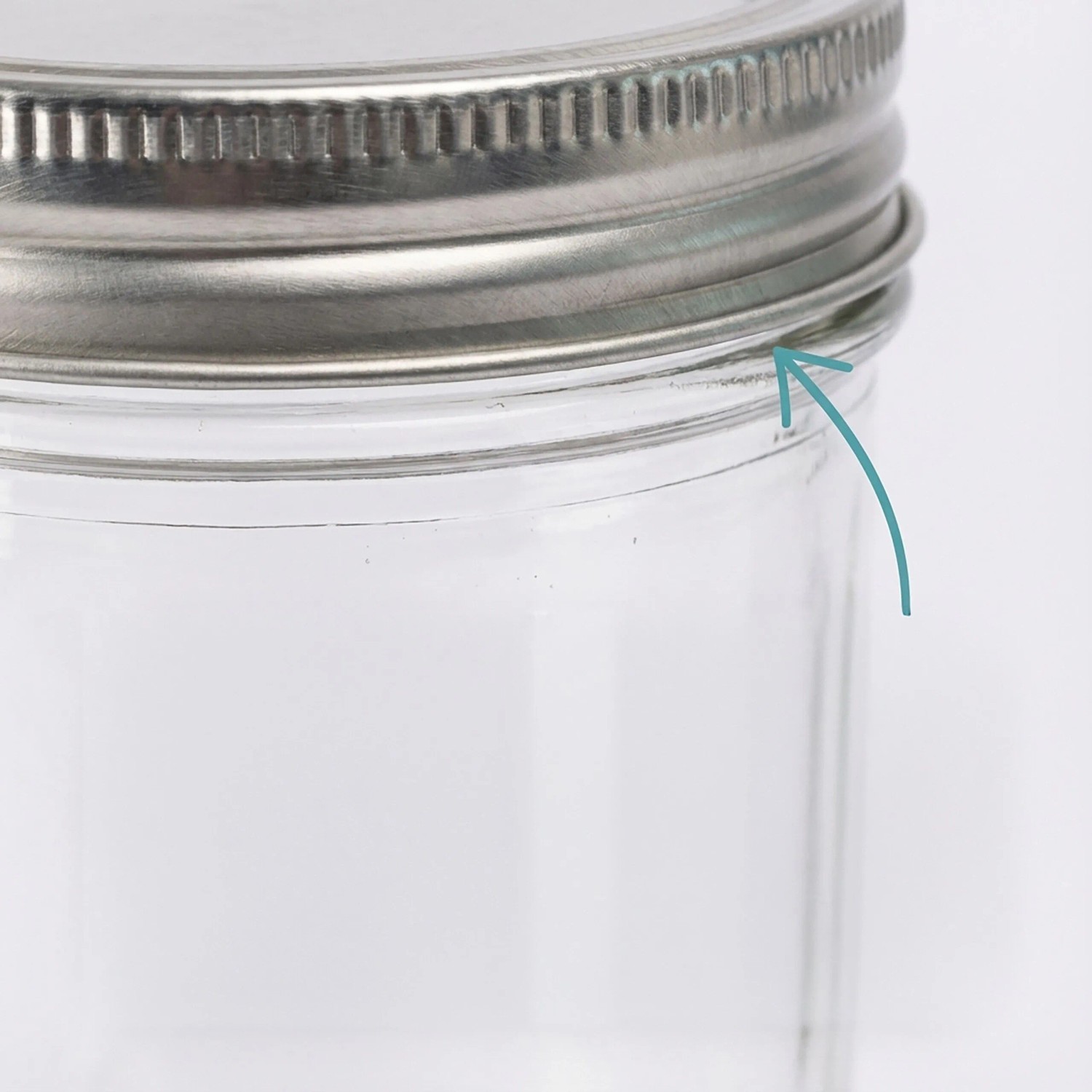 Nahaufnahme eines transparenten Einmachglases mit silbernem Schraubdeckel. Ein Pfeil zeigt auf den luftdichten Gummiring.