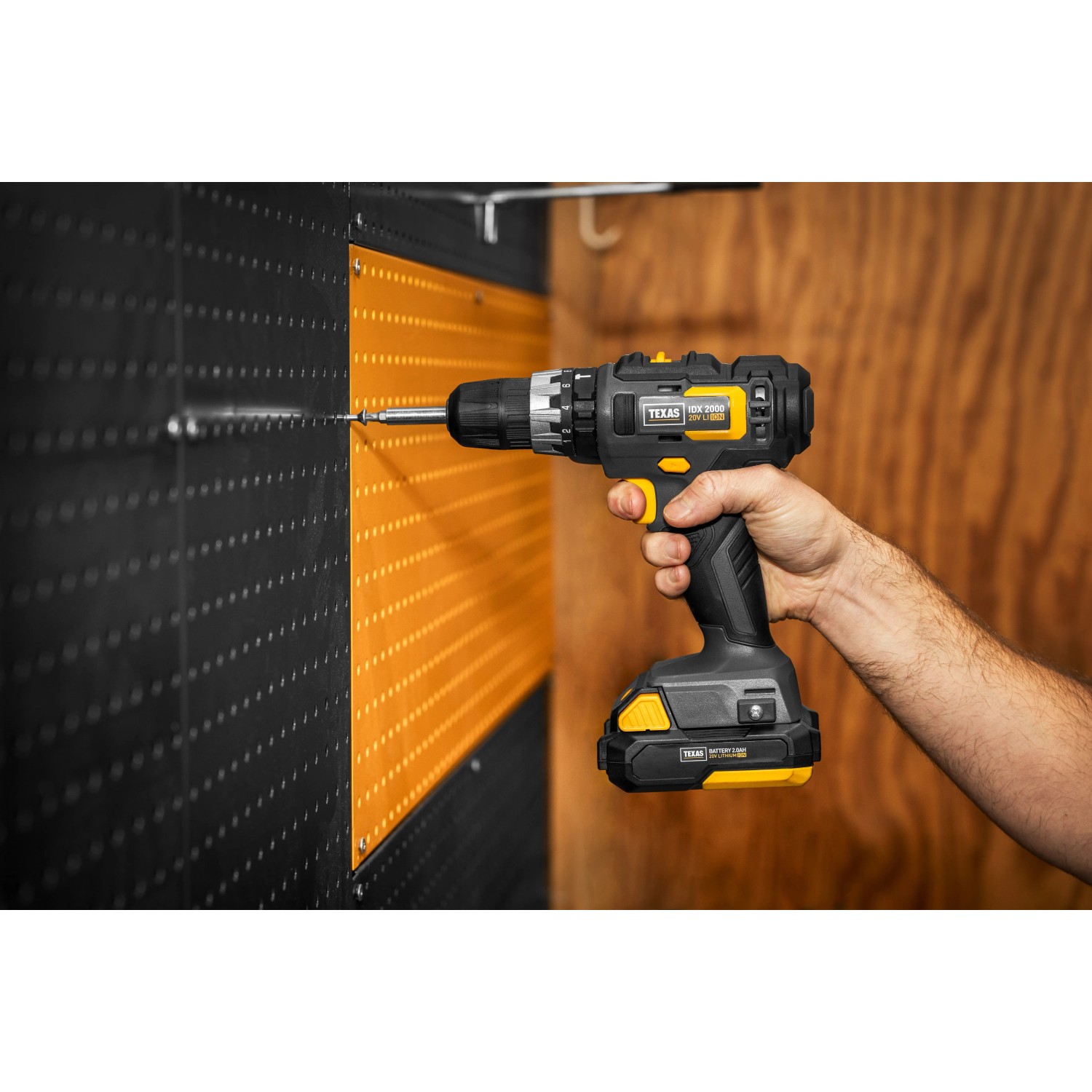 Texas 20V Schlagbohrmaschine IDX2000 beim Bohren in eine Wand. Akkuschrauber in Schwarz und Gelb.