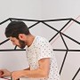 Mann benutzt Bosch Quigo Kreuzlinienlaser mit MM 2 Klemme zum Ausrichten eines Wandbildes.