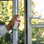 Anwendung von Ballistol Spray (50 ml) zur Pflege eines Fensterrahmens. Universalöl für Reinigung und Schutz.