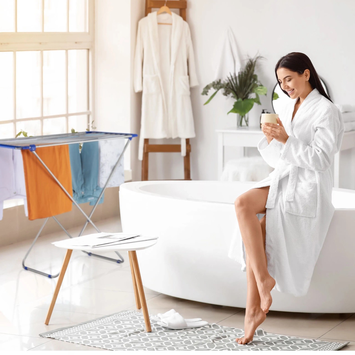 Ausziehbarer Relaxdays Wäscheständer aus Edelstahl, silber und blau, mit Wäsche im Badezimmer.