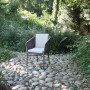 Anthrazitfarbener Acamp Manhattan Armsessel mit Kissen im Garten.