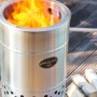 Feuerhand Pyron Feuertonne aus Edelstahl, 25 l, mit brennendem Feuer und Holzscheiten.