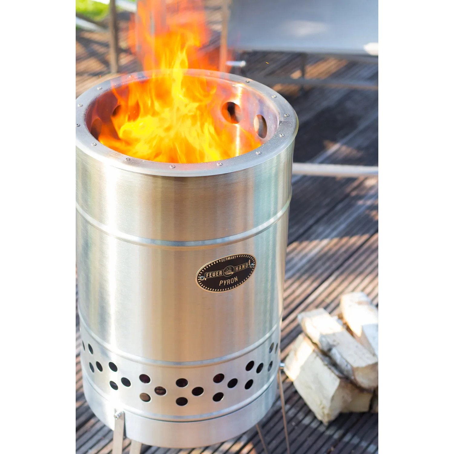 Feuerhand Pyron Feuertonne aus Edelstahl, 25 l, mit brennendem Feuer und Holzscheiten.