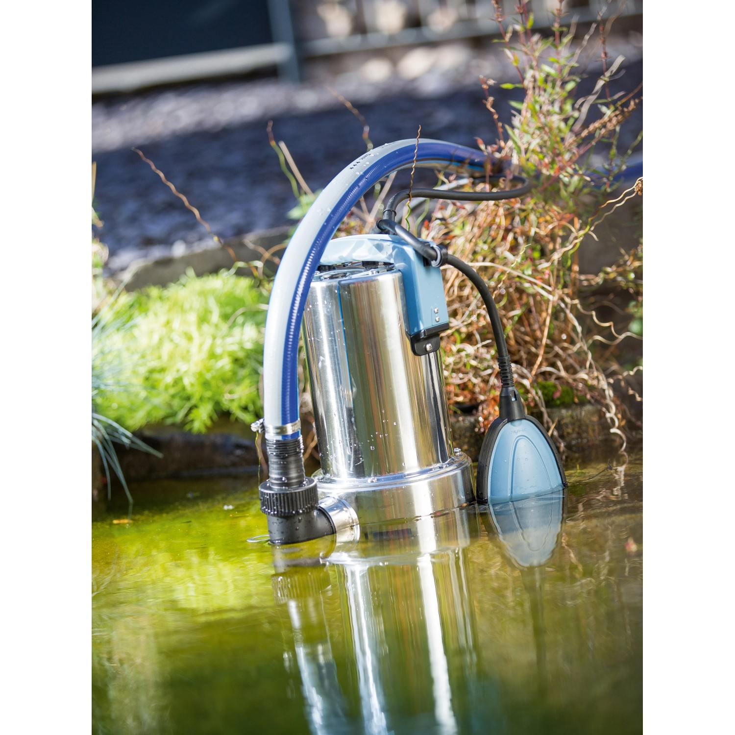 Tauchpumpe 1100 W im Wasser, Edelstahlgehäuse, blauer Schwimmer. Ideal für Schmutzwasser.