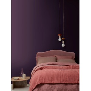 ELLE DECORATION Wandfarbe Pigment No. 472, matt, im Schlafzimmer mit rosa Bett und Lampe.