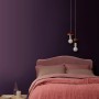 ELLE DECORATION Wandfarbe Pigment No. 472, matt, im Schlafzimmer mit rosa Bett und Lampe.