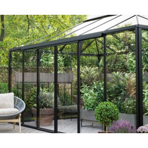 Elegantes Bloomcabin Pyramiden-Gewächshaus aus schwarzem Aluminium mit klaren Glaswänden, gefüllt mit Pflanzen im Garten.