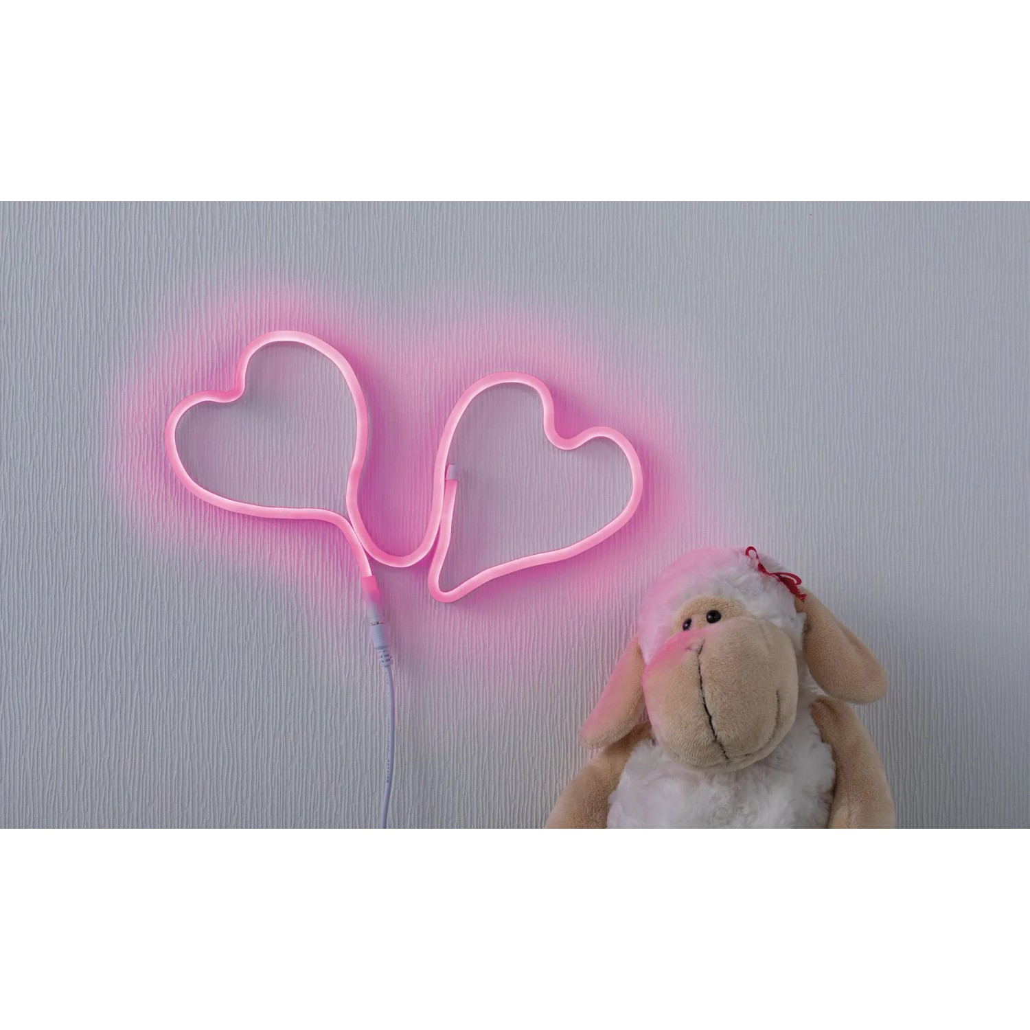 Pinker Paulmann LED Strip Neon Colorflex in Herzform, neben einem Stofftier.