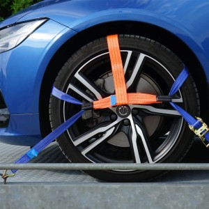 Auto auf Anhänger mit Wiltec Spanngurt-Set zur Radsicherung, bestehend aus orangefarbenen und blauen Gurten.
