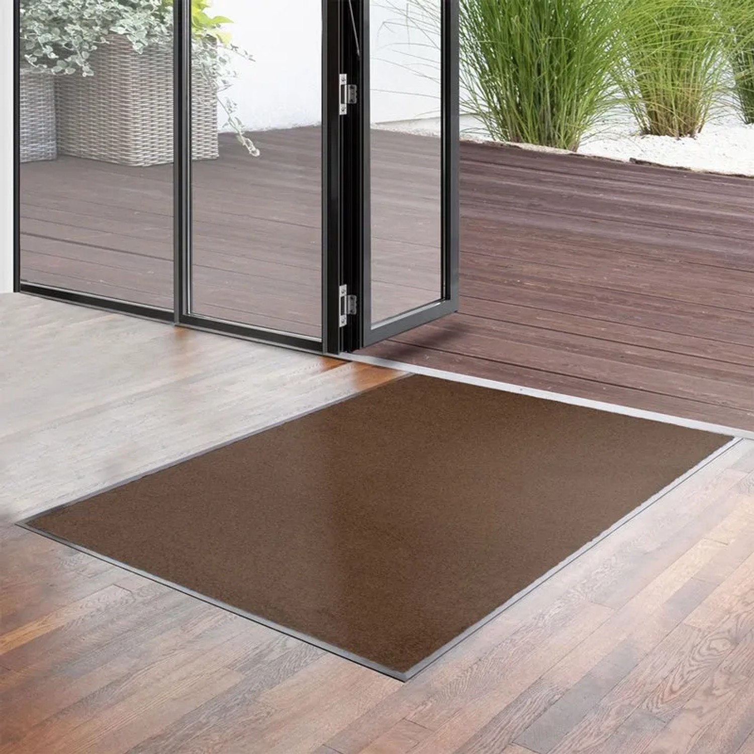 Braune KARAT Fußmatte Performa 90x120 cm vor einer Terrassentür. Universal Schmutzfangmatte für den Innenbereich.