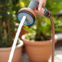 Gardena Comfort Multibrause in Aktion: Hand hält Brausekopf, Wasserstrahl sichtbar.