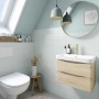 Badezimmer mit Wandfarbe in Agave, Waschtisch mit Holzunterschrank, WC und Spiegel.