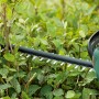 Bosch UniversalHedgeCut 18-55 Akku-Heckenschere beim Schneiden einer Hecke.