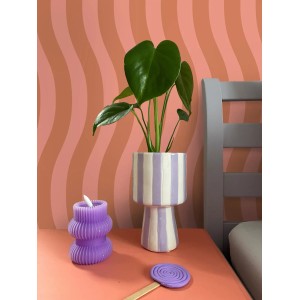 ESTAhome Vliestapete mit rosa wellenförmigen Streifen an einer Wand, dekoriert mit Pflanze und Kerze.