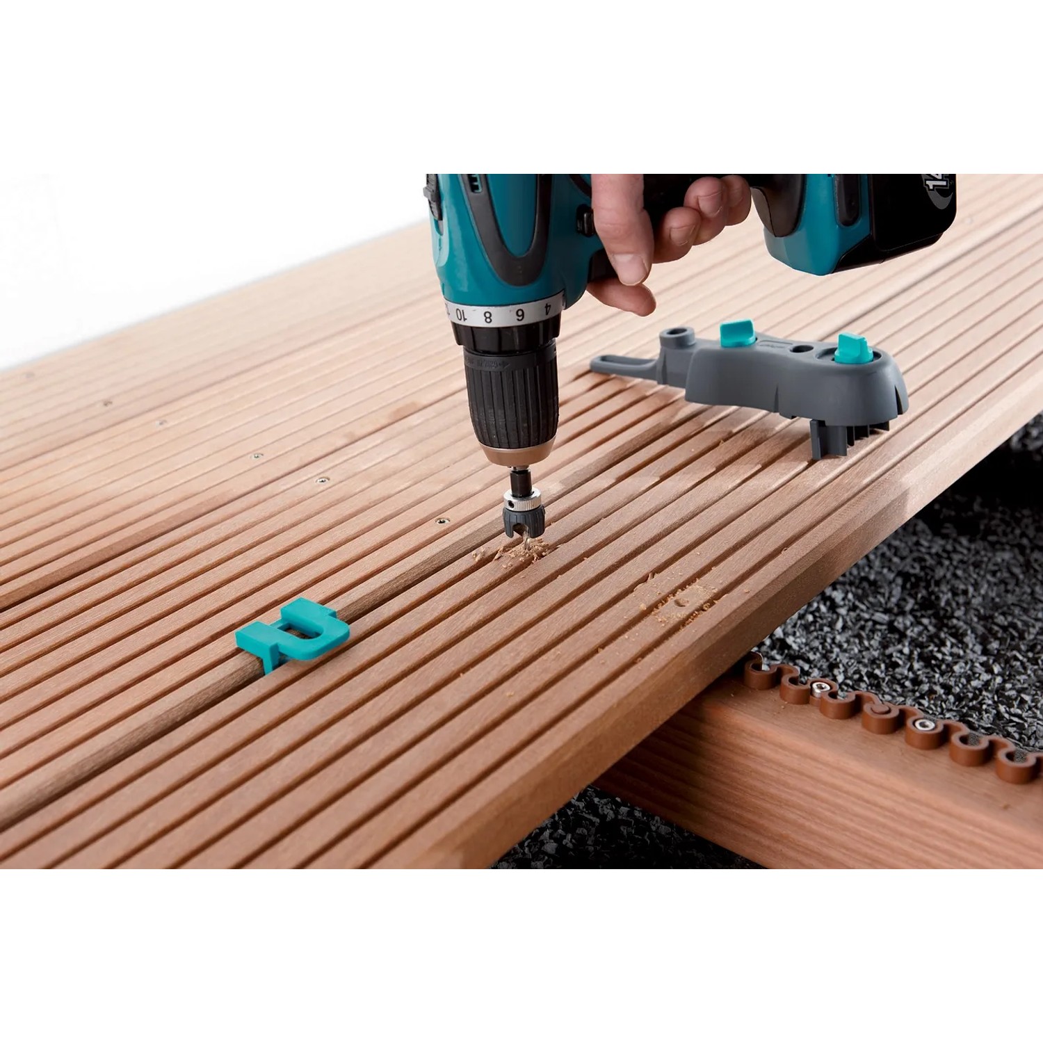 wolfcraft Terrassenbau Set in Nutzung: Bohren einer Terrassendiele mit Bohrmobil und Vorbohrer.