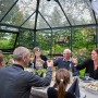 Familie feiert im Juliana Gewächshaus Grand Oase 13 Anthrazit mit Walmdach.