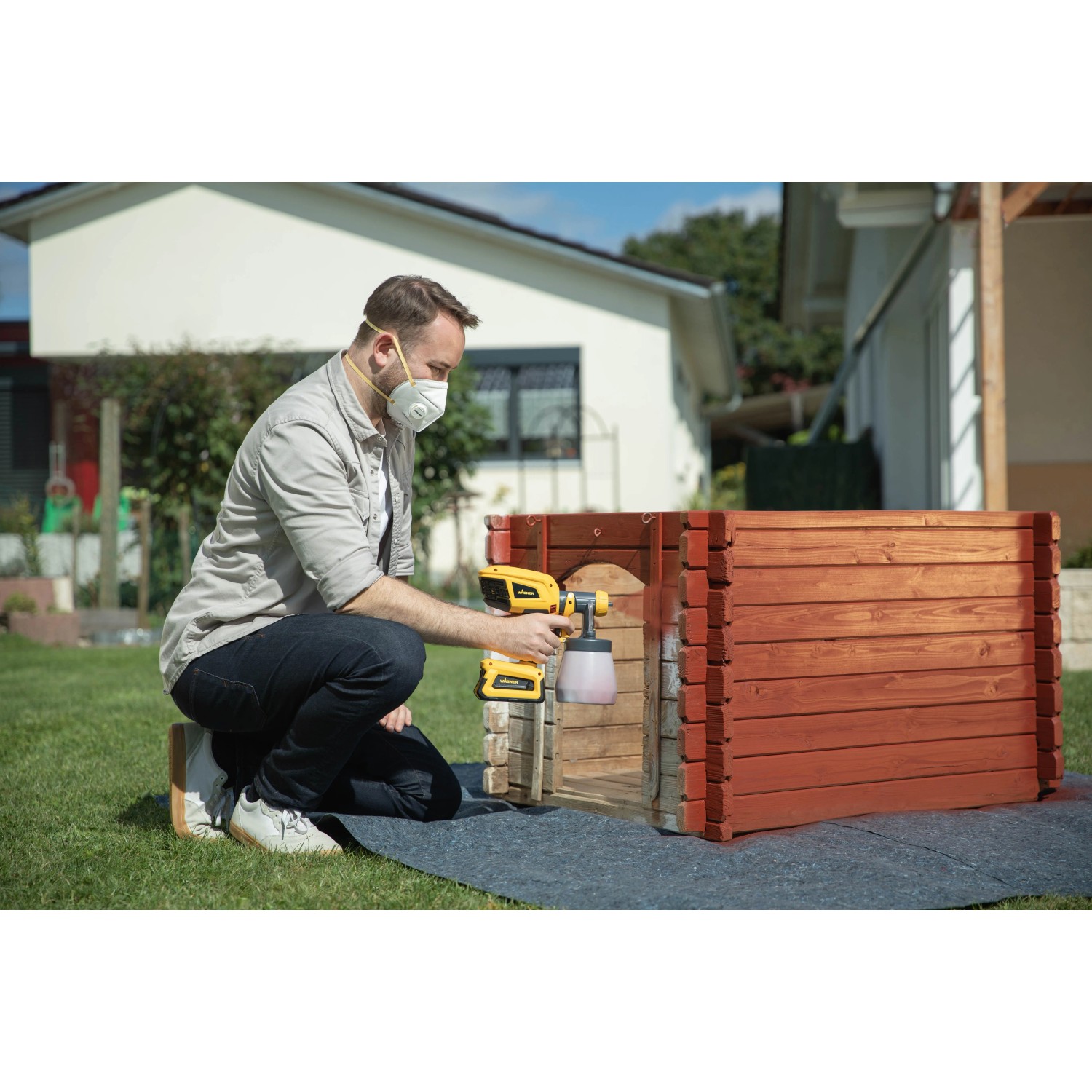 Mann sprüht Holz mit Wagner Akku-Farbsprühsystem W 600 FLEXiO. Sprühgerät für Farben und Lacke.