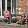 Siena Garden Sessel mit altrosa Stella Auflagen auf Terrasse, Esstisch mit Stühlen.