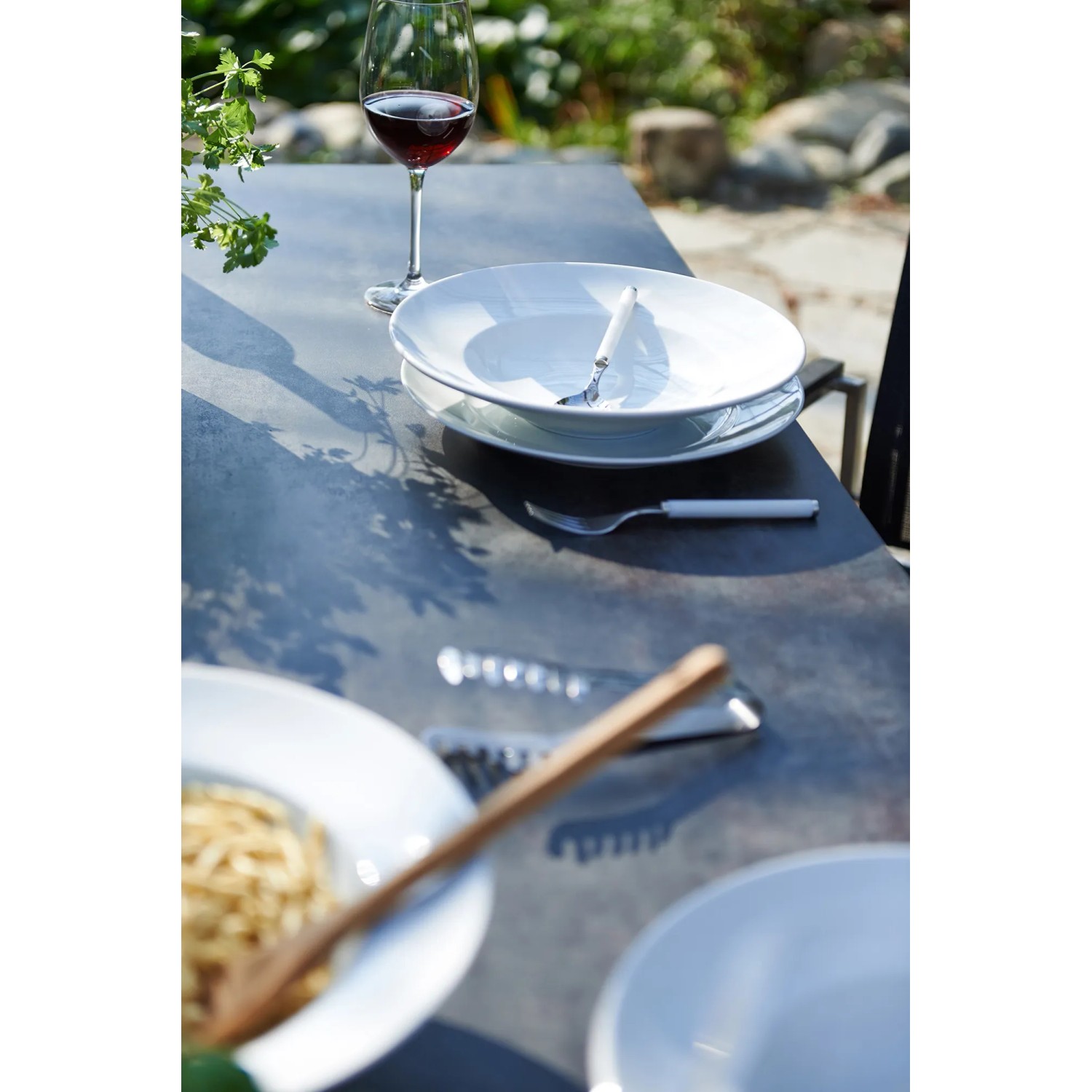 Gedeckter Tisch des Acamp Gartenmöbel-Sets Auris mit Edelstahl-Gestell und Speisen.