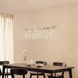 Moderne, 10-flammige Lucande Pendelleuchte Bellora aus Chrom und Kristall über Esstisch.