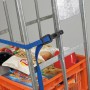 Blauer, längenverstellbarer Gummi-Expander mit Kunststoffhaken sichert Ladung auf einer Sackkarre.