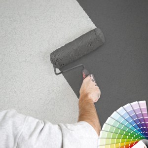 Mann streicht weiße Vliestapete mit Marmor Effekt grau. Farbpalette im Bild.