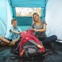 Familie im Pavillo Zelt Family Ground 4 beim Packen eines Rucksacks für den Campingausflug.