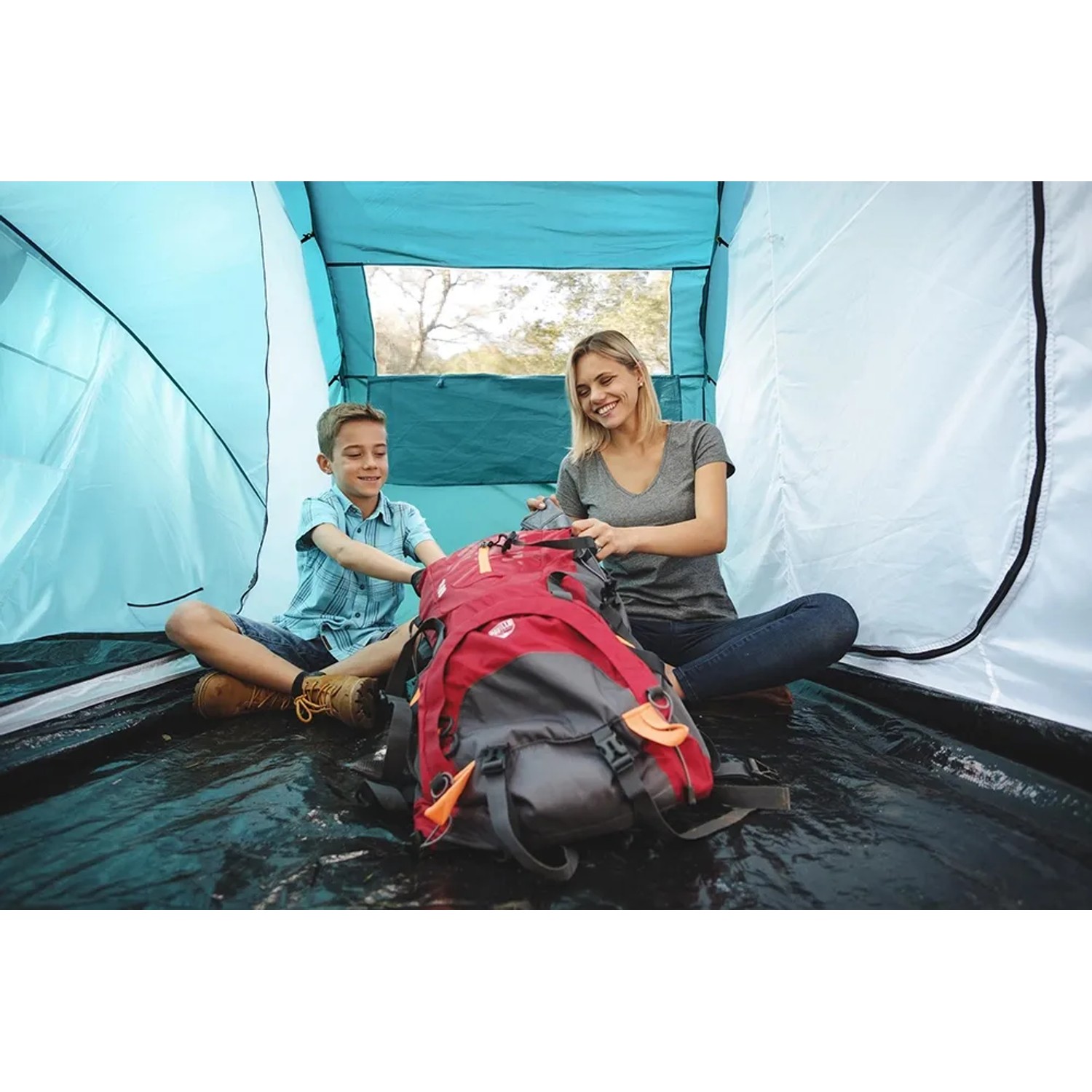 Familie im Pavillo Zelt Family Ground 4 beim Packen eines Rucksacks für den Campingausflug.