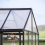 Detailaufnahme: Schwarzes Palram Canopia Gewächshaus Triomphe mit Polycarbonatplatten und Fundamentrahmen.