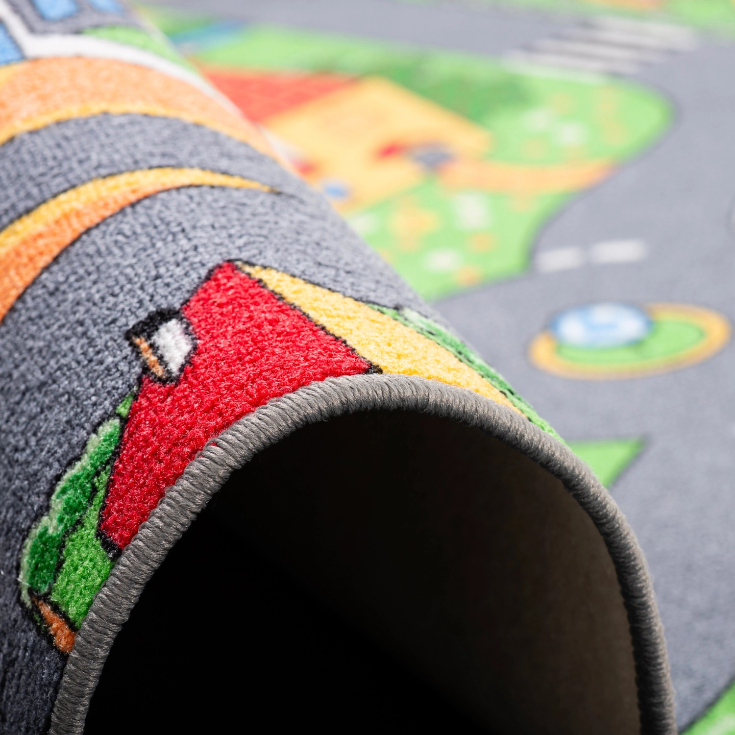 Detailansicht: Bunter Kinder Spielteppich Little Village 160x240cm mit Straßen und Häusern.
