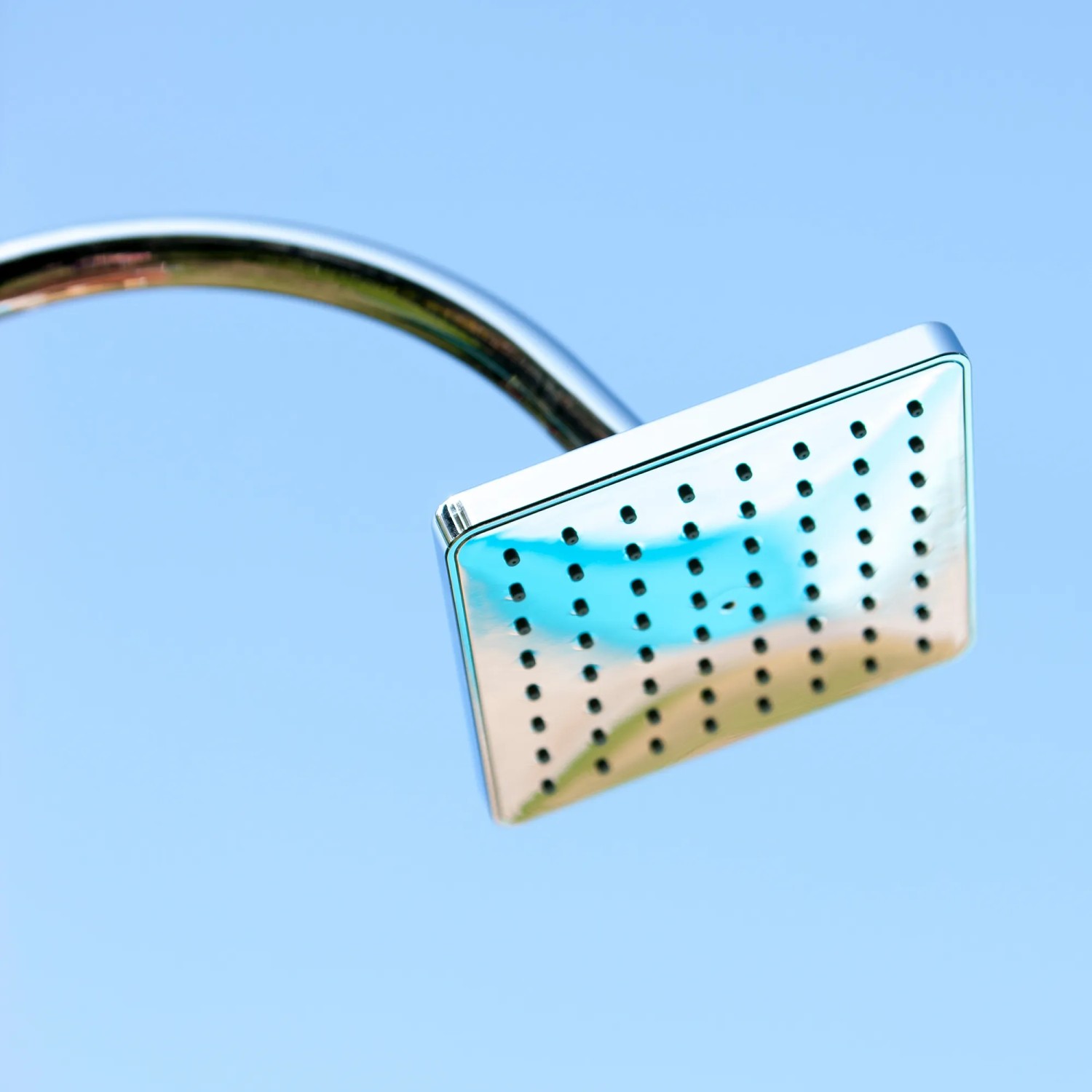 Detailaufnahme des Duschkopfs der schwarzen Gre Solardusche aus Aluminium (18 l) vor blauem Himmel.