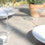 Detailansicht des Acamp Gartenmöbel-Sets Alpha mit Glastisch, Geschirr und Gläsern im Freien.