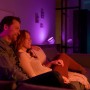 Paar entspannt auf Sofa, beleuchtet durch Philips Hue Iris Tischleuchte in Weiß und Farbe.