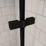 Schwarze Scharniere und Rahmen der Duschkabine. Detail des Duschabtrennung-Mechanismus vor weißen Fliesen.