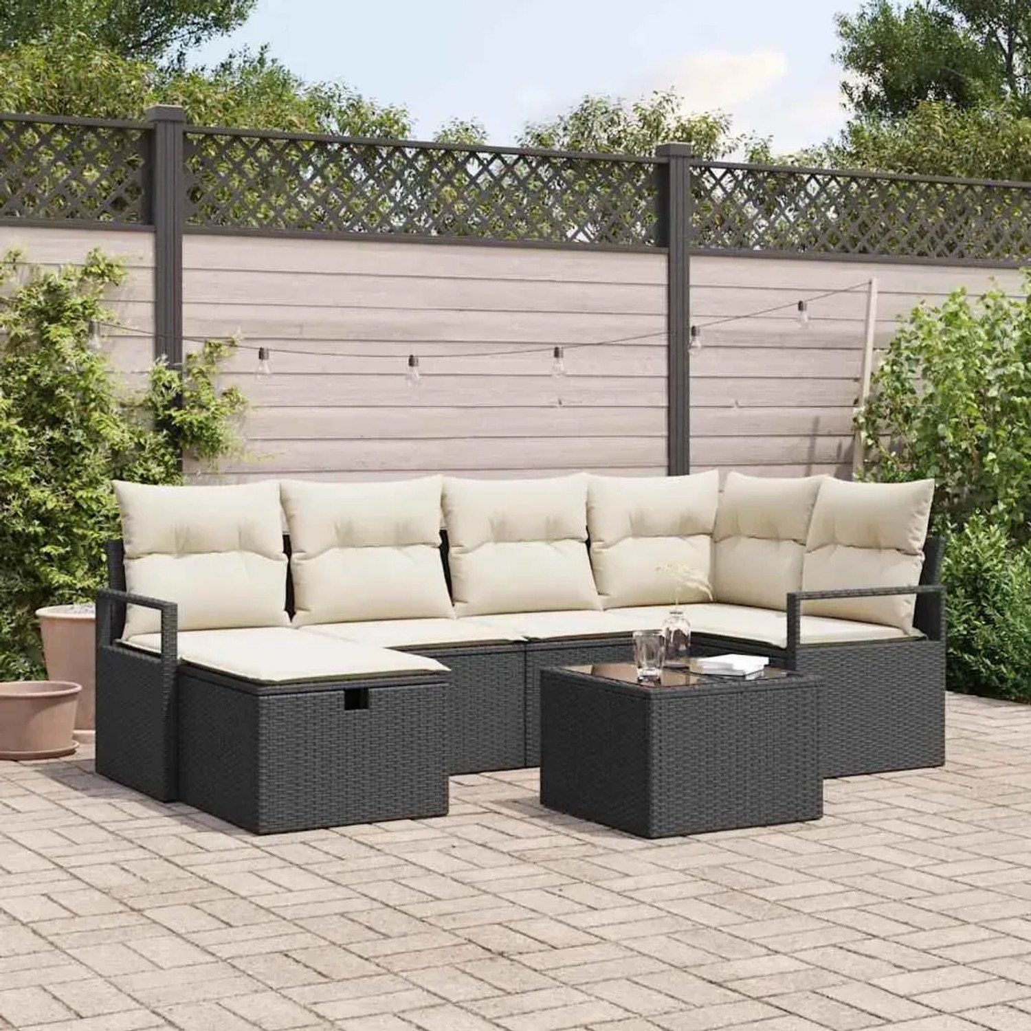 Schwarzes 7-teiliges Garten-Sofa-Set aus Poly Rattan mit Kissen und Tisch.
