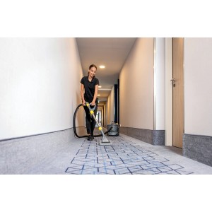 Frau reinigt Teppich mit Kärcher CarpetPro RM 764N Sprühextraktionsgerät. Reinigungsmittel & Pflegemittel.