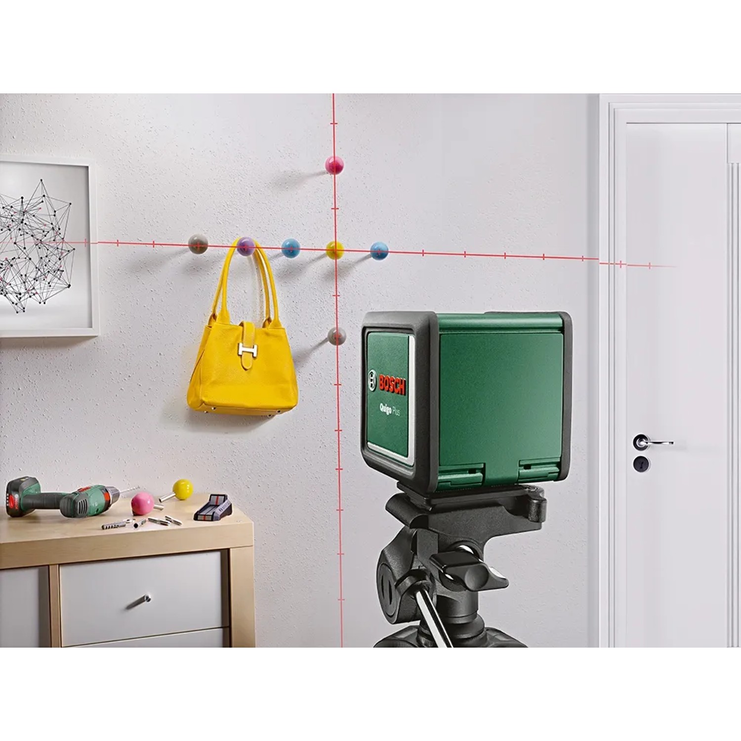 Bosch Quigo Plus Kreuzlinienlaser mit Stativ im Einsatz: Ausrichten von Deko mit Laserlinien.