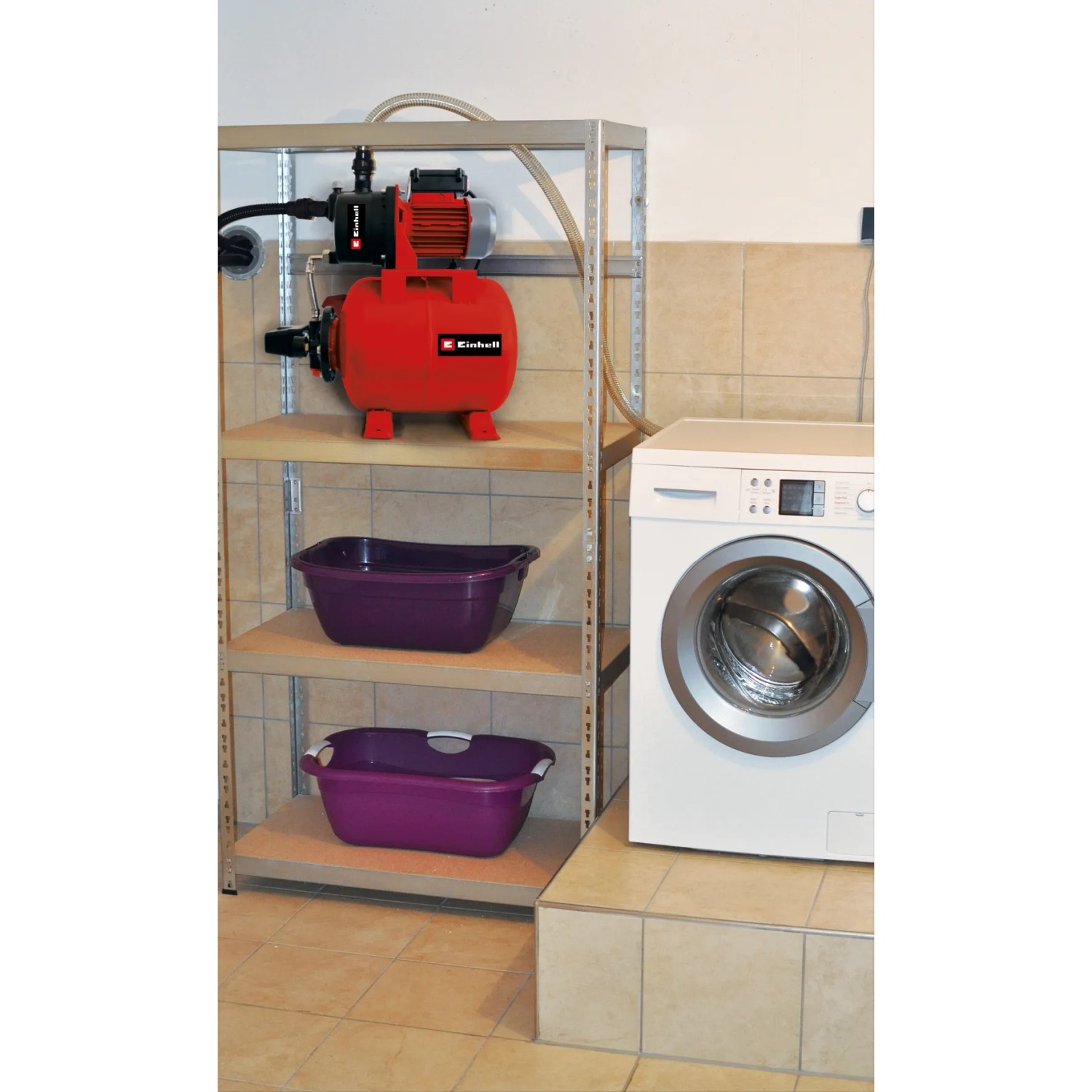 Einhell Hauswasserwerk GC-WW 6839 auf Regal, neben Waschmaschine. Rote Pumpe mit Stahlkessel.