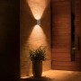 Silberne Philips Hue Resonate LED-Außenwandleuchte an einer Hauswand mit warmem Licht.