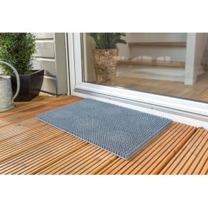 Graue Astra Fußmatte Season 40x60 cm vor einer Haustür auf Holzterrasse.