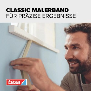 tesa Malerband Classic: Mann klebt beiges Abklebeband an blaue Wand für präzise Farbkanten beim Streichen.