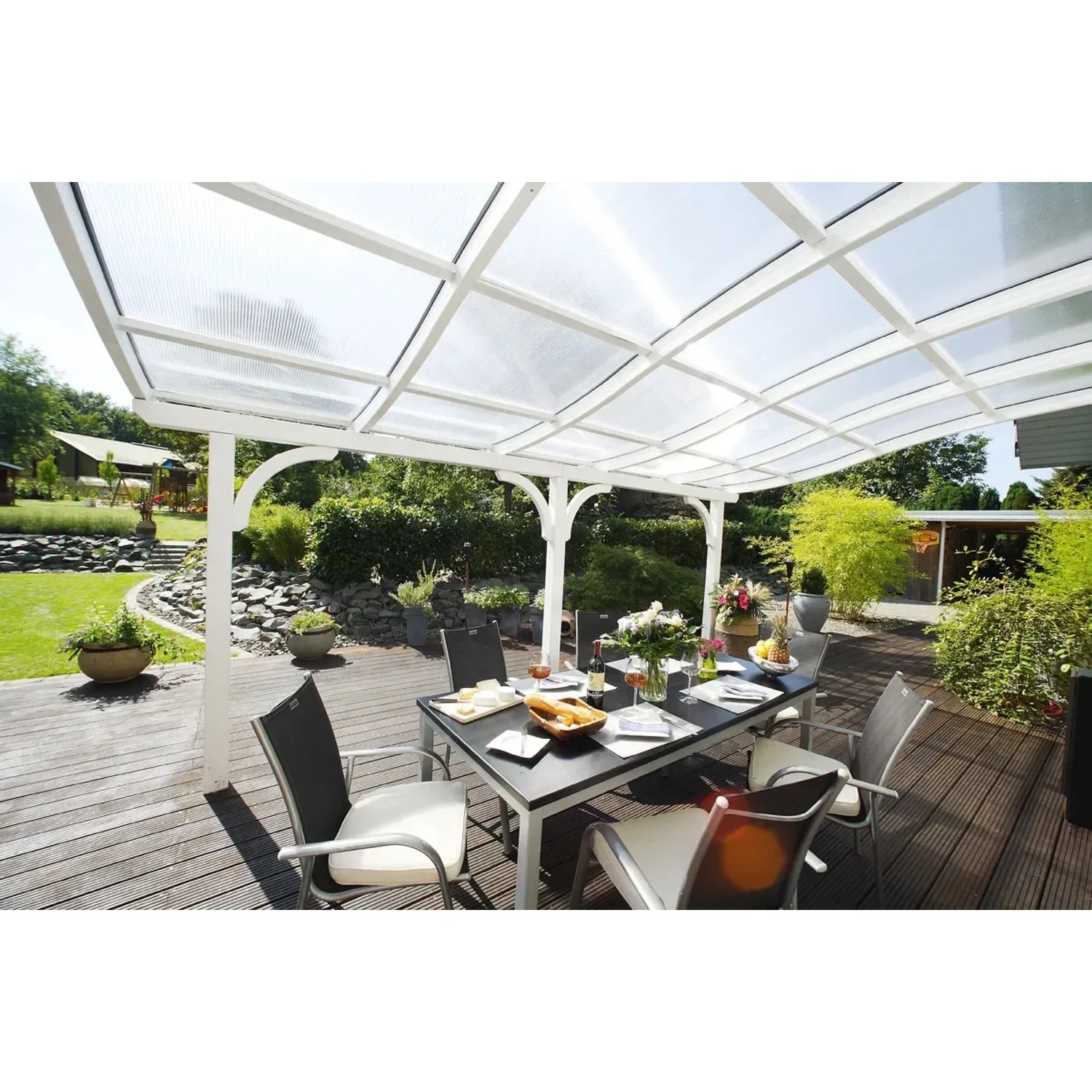 Skan Holz Terrassenüberdachung Venezia, 541x289 cm, Nussbaum Leimholz mit Sitzgruppe auf Terrasse.