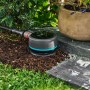 Gardena Smart Pipeline Water Control Bewässerungscomputer im Garten, verbunden mit Schlauch.