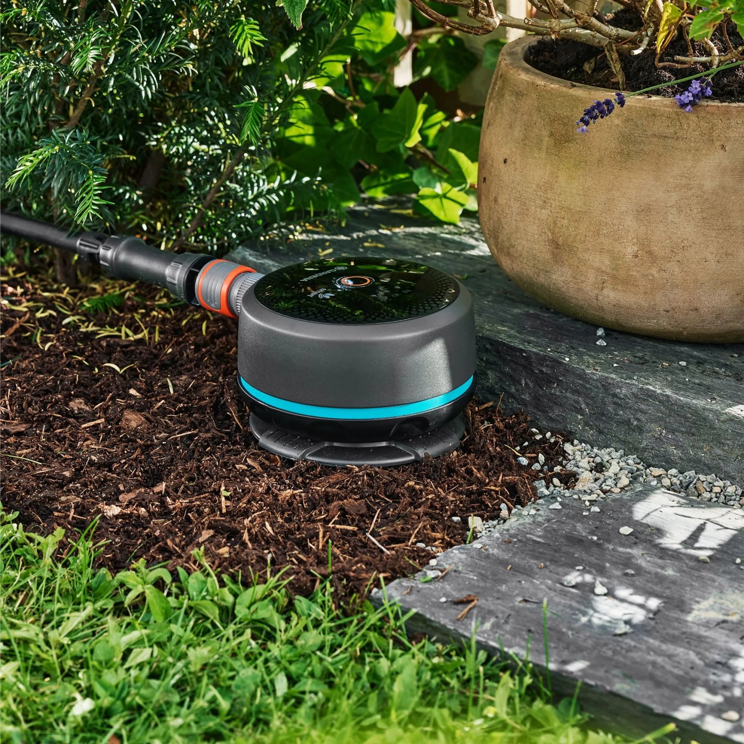 Gardena Smart Pipeline Water Control Bewässerungscomputer im Garten, verbunden mit Schlauch.
